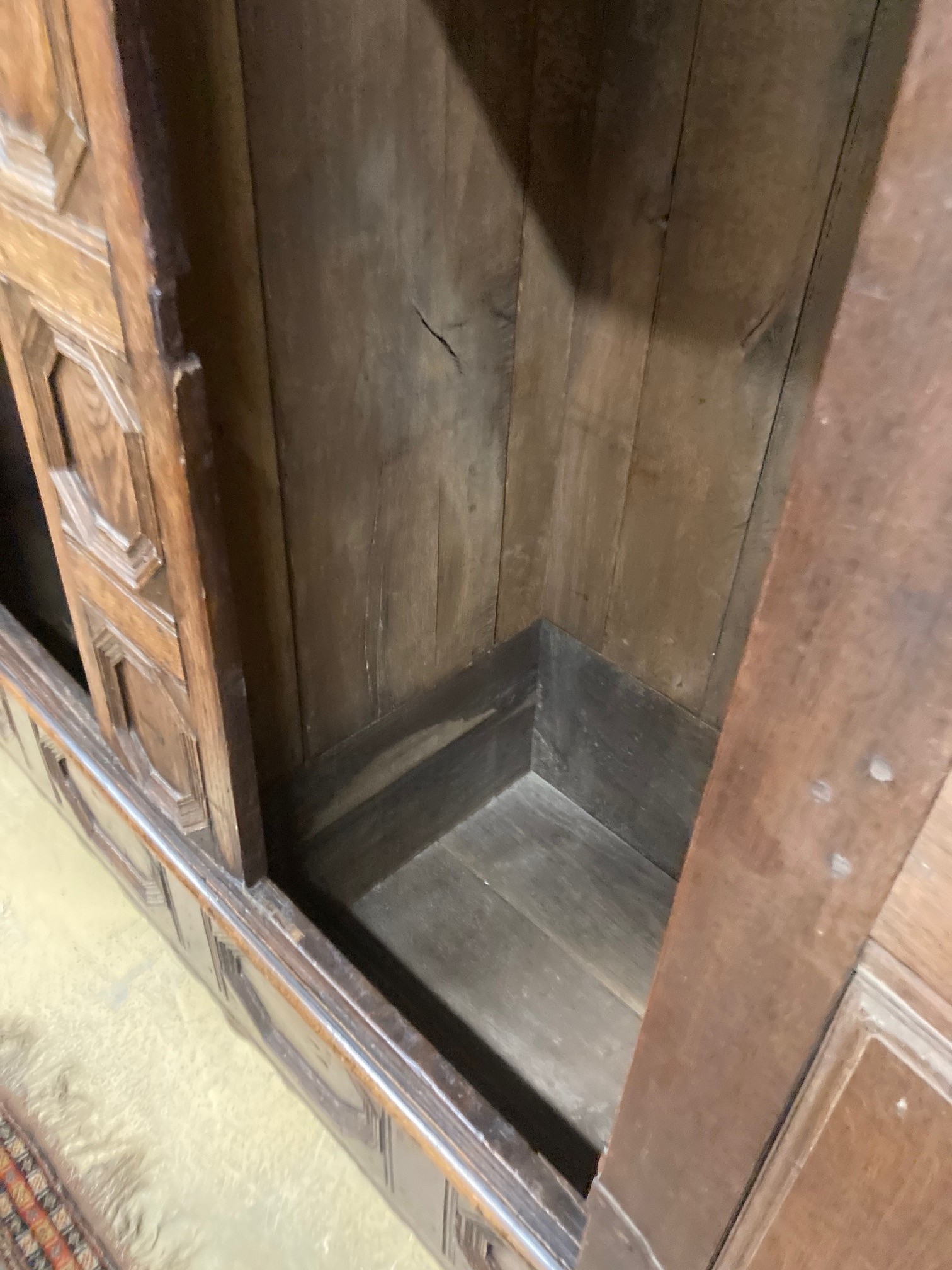 A 17th century and later panelled oak cupboard, length 194cm, depth 70cm, height 198cm